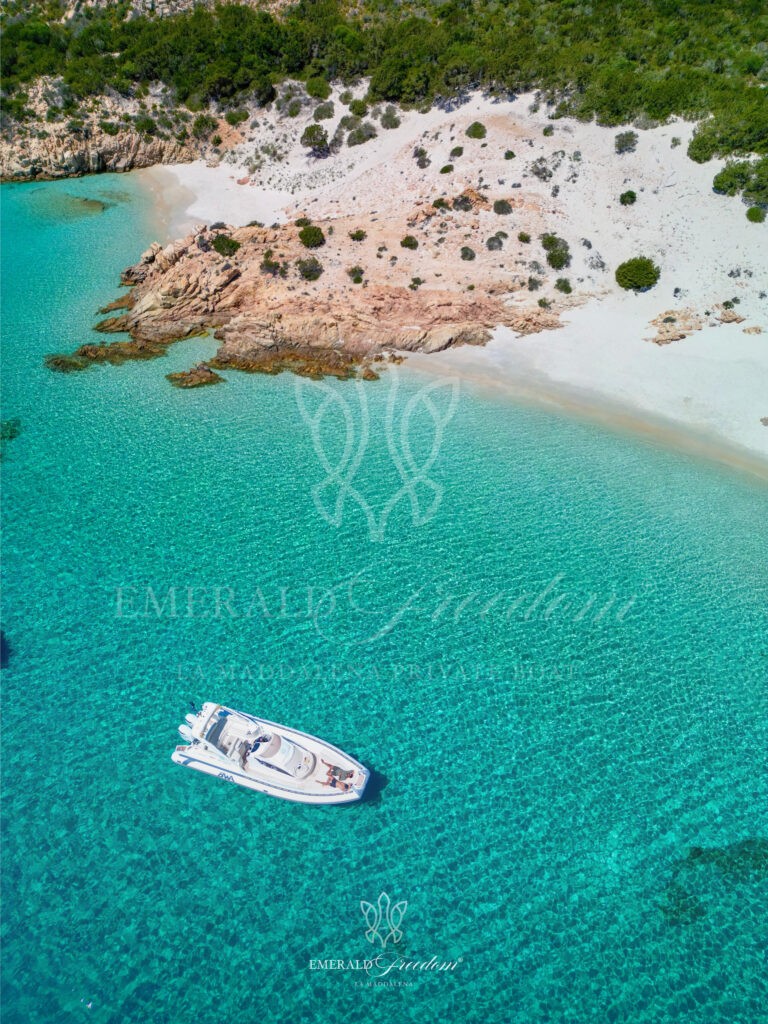 RIB boat approaching a stunning turquoise cove in La Maddalena